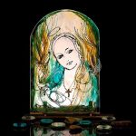 Hand painted glass icon of Our Lady with gentle expression and warm glow