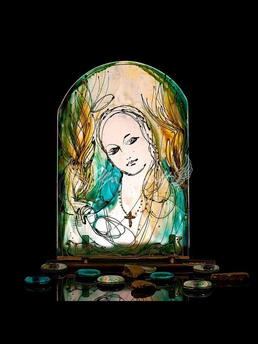 Hand painted glass icon of Our Lady with gentle expression and warm glow